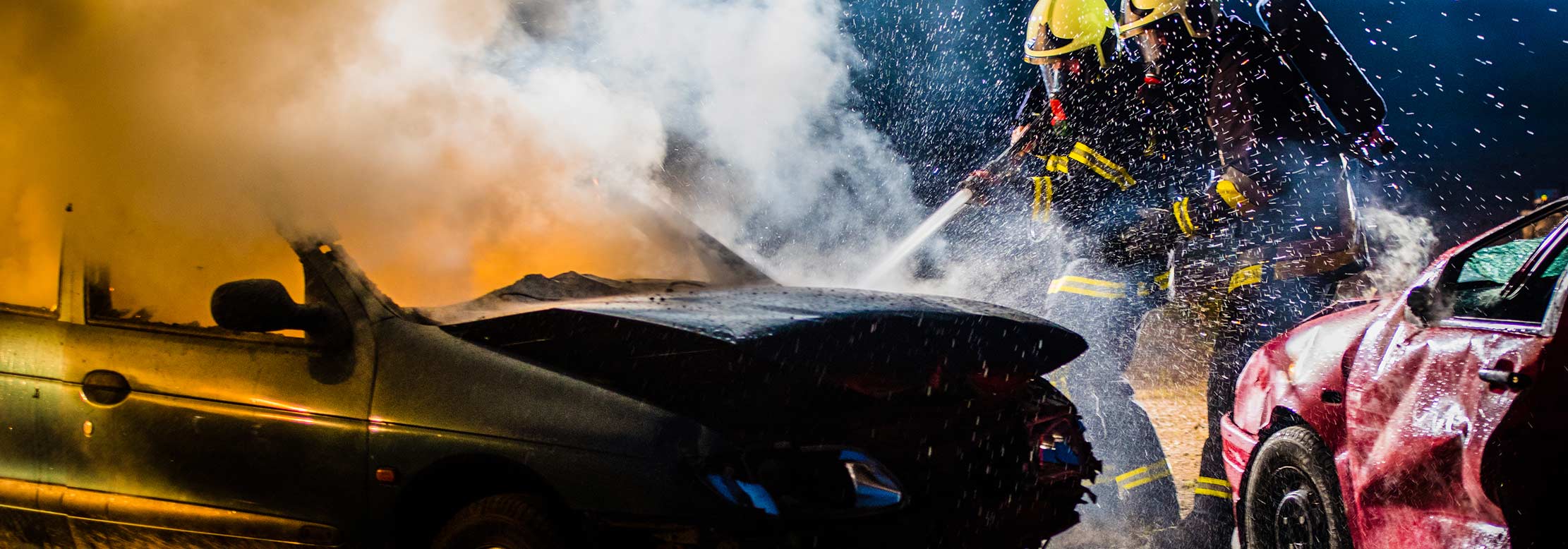 Firefighters attempt to stop a car from burning.