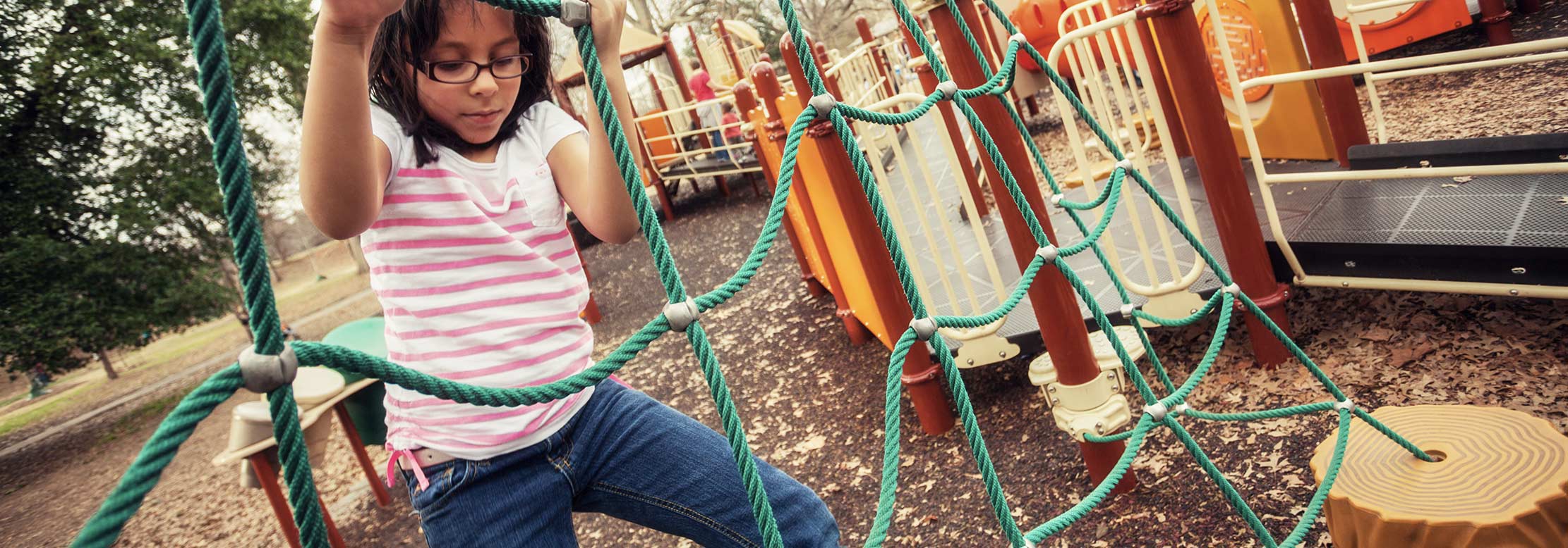 Child plays in park playground.