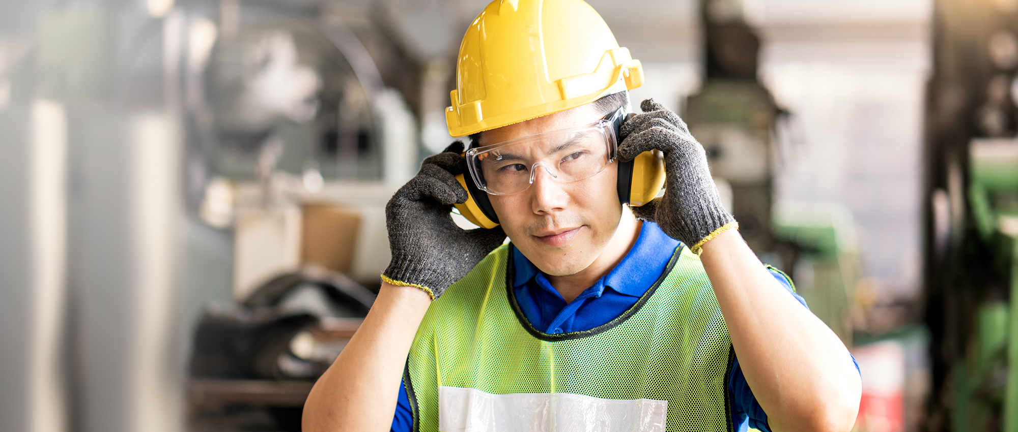 Worker adjusts hearing protective equipment.