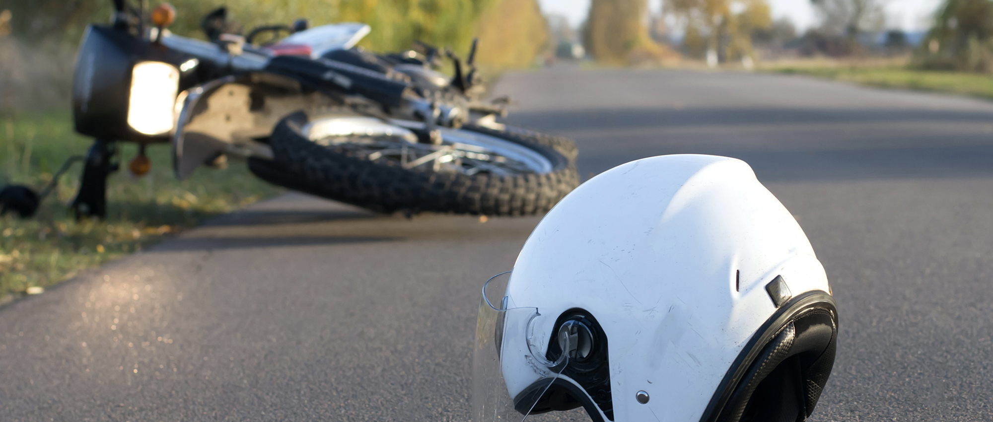 Motorcycle and helmet lie on the road after an accident.