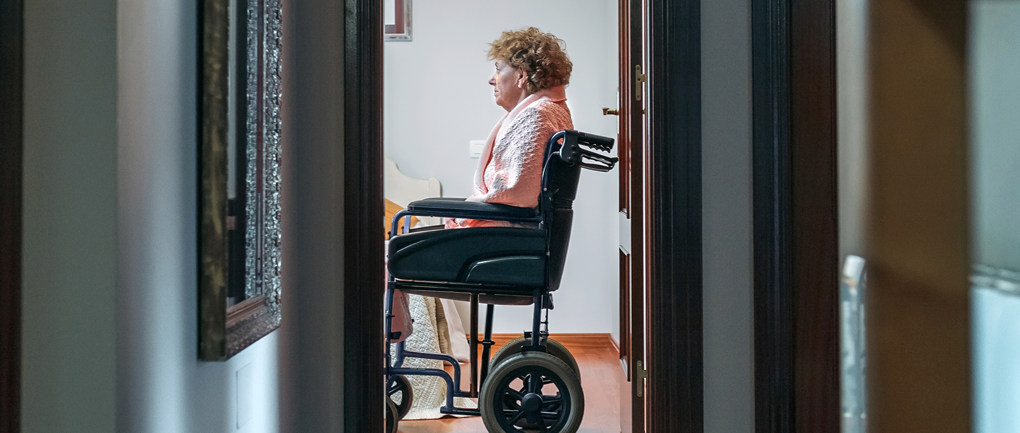 Elder woman sits impatiently on wheelchair waiting to receive attention.