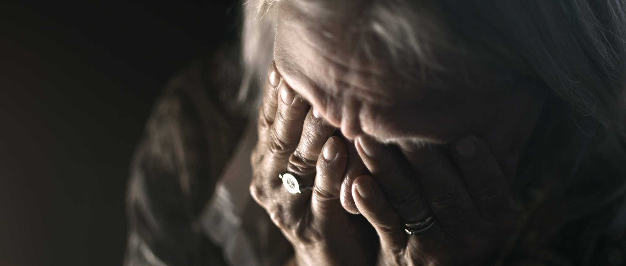 Older woman cries with sorrow.