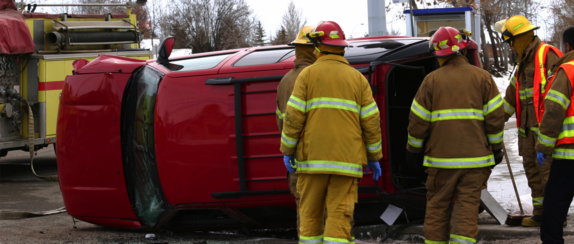 Paramedics help next to a SUV lying on its side after a rollover accident.