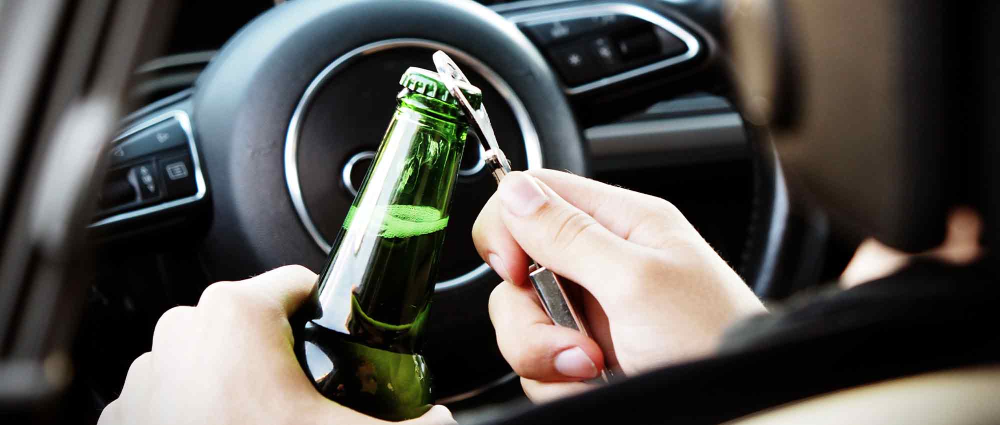 Motorist opens a beer bottle while about to get on the road.