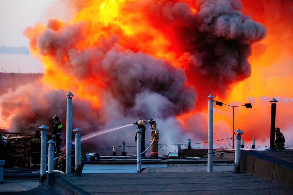 Firefighters extinguishing a fire in a burning industrial building in the city.