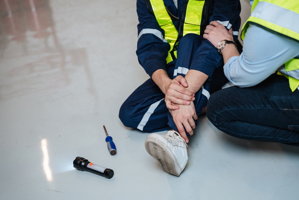 An engineer requests assistance after a team member sustains a leg injury during electrical work.