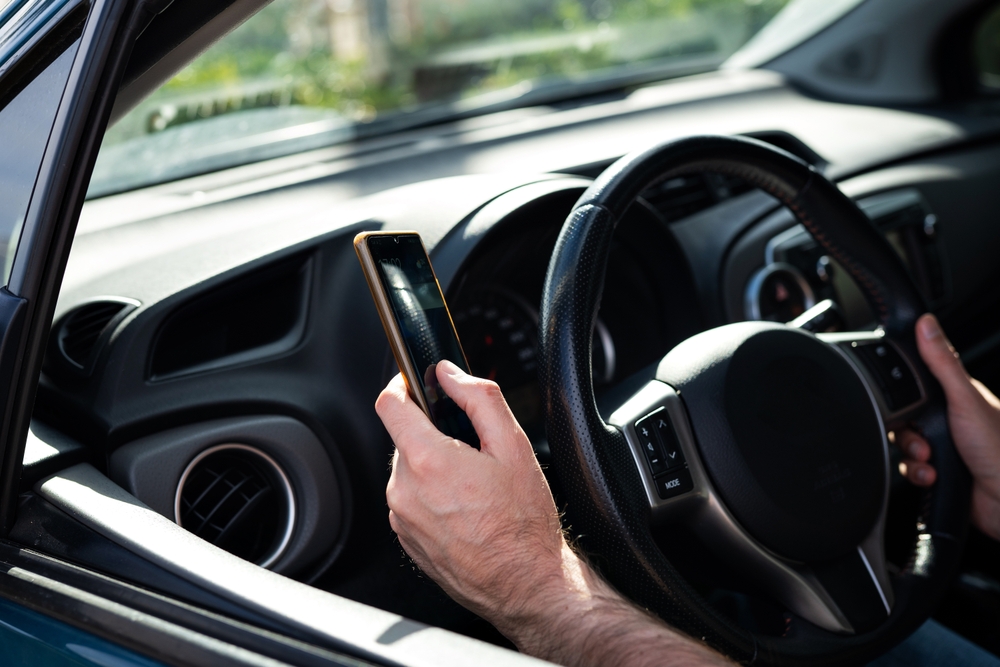 A driver using a phone while driving a car.