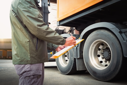 a person inspecting a truck with a clipboard, representing the process of gathering and preserving vital evidence in a truck accident case