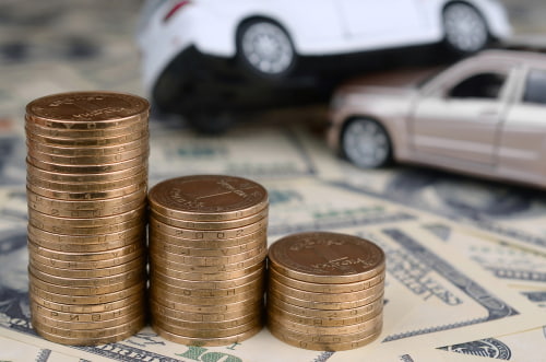 two cars and money, representing the negotiation of a settlement for an accident injury claim