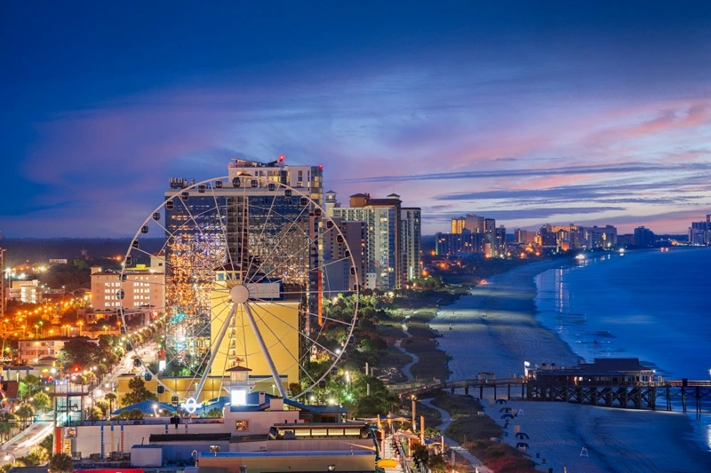 A view of hotels and shops along the Myrtle Beach coast at night time