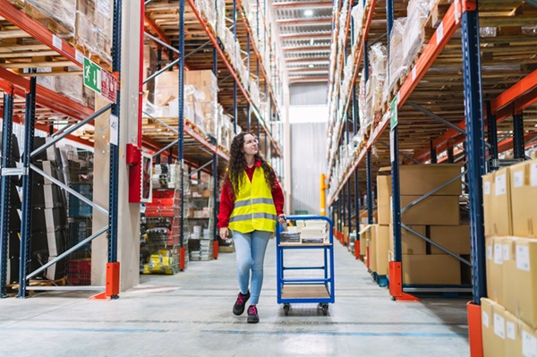 A young worker in a warehouse, representing an area where workplace injuries can happen.
