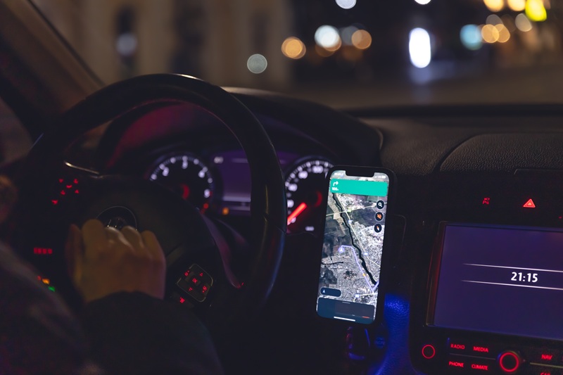 Navigator in a smartphone in a car at night, close-up, view from the car interior.