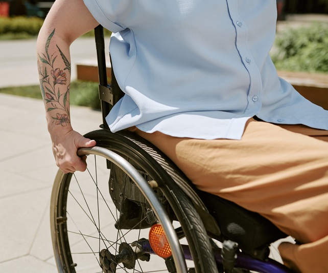 A man sits in a wheelchair. He suffered a catastrophic injury leaving him unable to walk.
