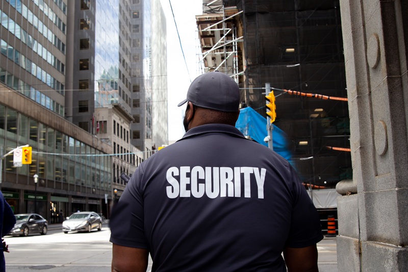 А security guard in uniform patrolling a residential area.