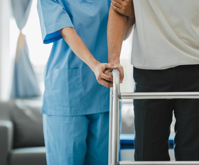 Medical professional helping a patient learn how to walk again