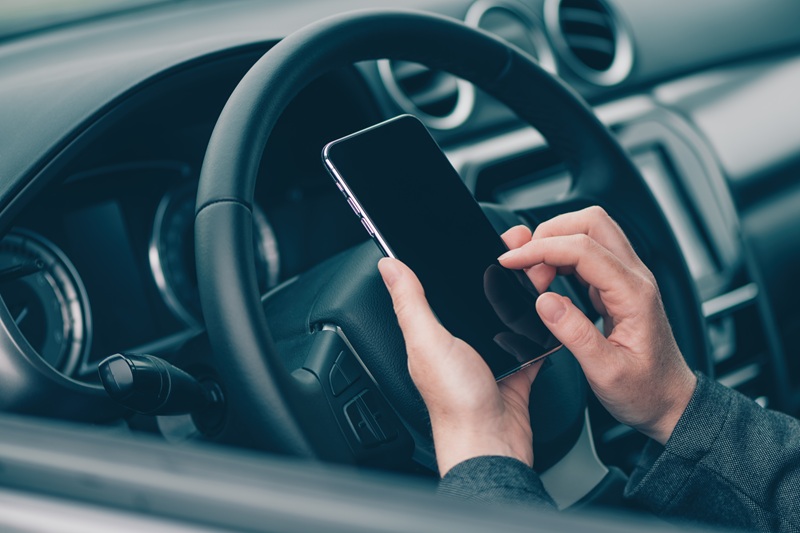 Woman using mobile phone for text messaging in car, close up of female hand and smartphone device in vehicle, selective focus